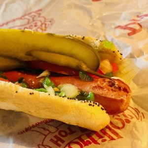 A Chicago-style hot dog in a wrapper.