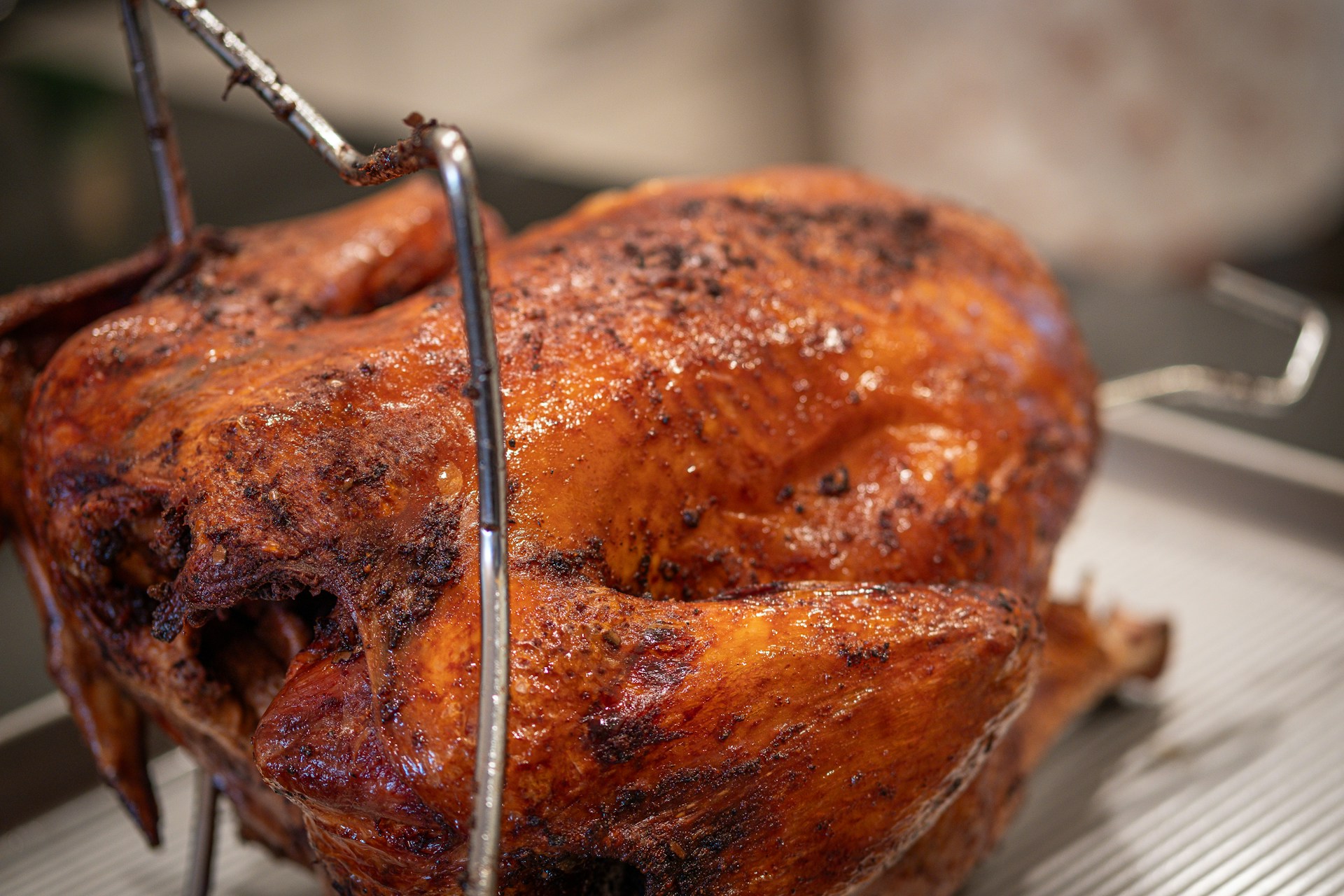 A deep-fried turkey sits in a hook before dipping.